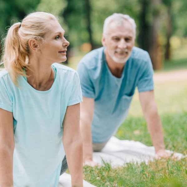 couple doing yoga on lawn