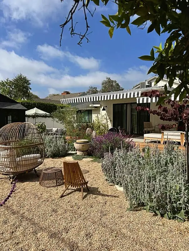 Sun Drenched Gravel Courtyard with Striped Awning